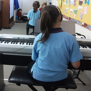 Girl playing keyboard at school